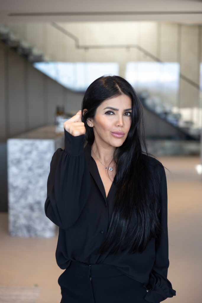 Asal Almawy in a black blouse inside a modern home